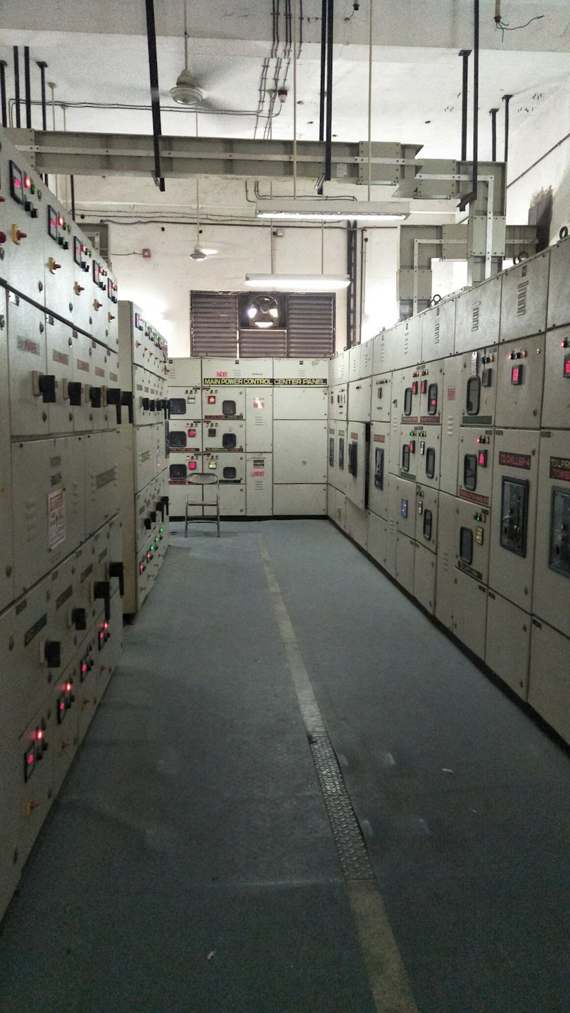 Industrial corridor with electrical control panels and main power center.